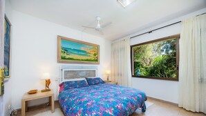 A bedroom with a bed, a nightstand, a ceiling fan, a window with curtains, and a painting on the wall. - Holiday Home 'Can Bennassar' with Private Terrace, Balcony and Wi-Fi (Cala Sant Vicenç)