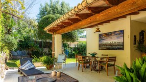 An outdoor patio with a wooden table, chairs, and a sofa. - Holiday Home 'Can Bennassar' with Private Terrace, Balcony and Wi-Fi (Cala Sant Vicenç)