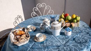 A table set with tea service, fruit, pastries, and a basket of bread. - A Place in the Sun - Caltanissetta (Caltanissetta)
