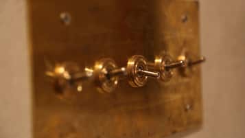 A close-up of a brass-colored electrical switch plate with multiple switches.