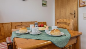 A dining table with bread, eggs, and a clock on the wall. - Völlig Ausgeglichen: Die Erdgeschoss-wohnung Liegt in Unmittelbarer Nähe des Kur (Carolinensiel)