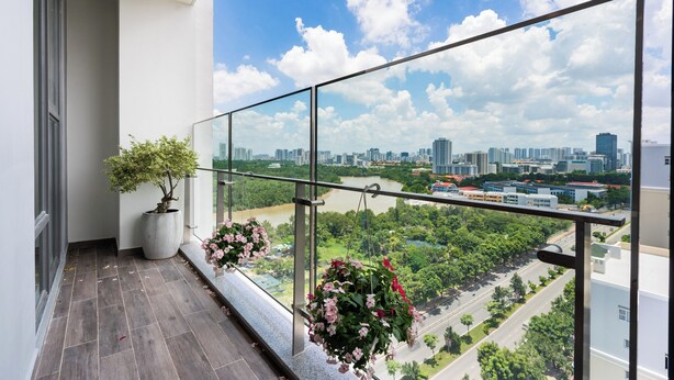 Ein Balkon mit Blick auf die Stadt, einem Blumentopf und hängenden Blumen.