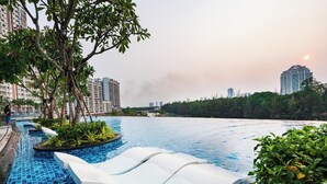 Ein Schwimmbecken mit abgestuften Stufen und Blick auf hohe Gebäude im Hintergrund.