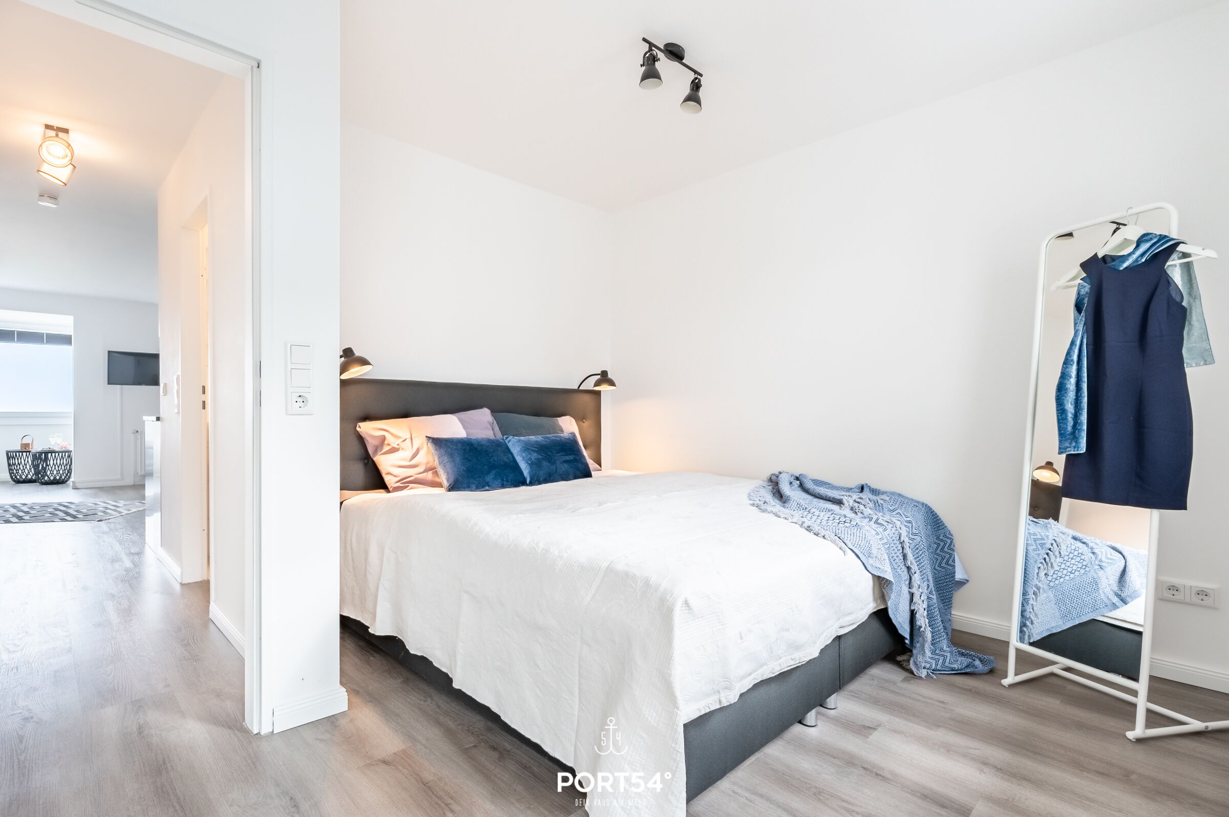 Une chambre à coucher moderne avec un lit, des lampes de chevet, une armoire et un luminaire suspendu.