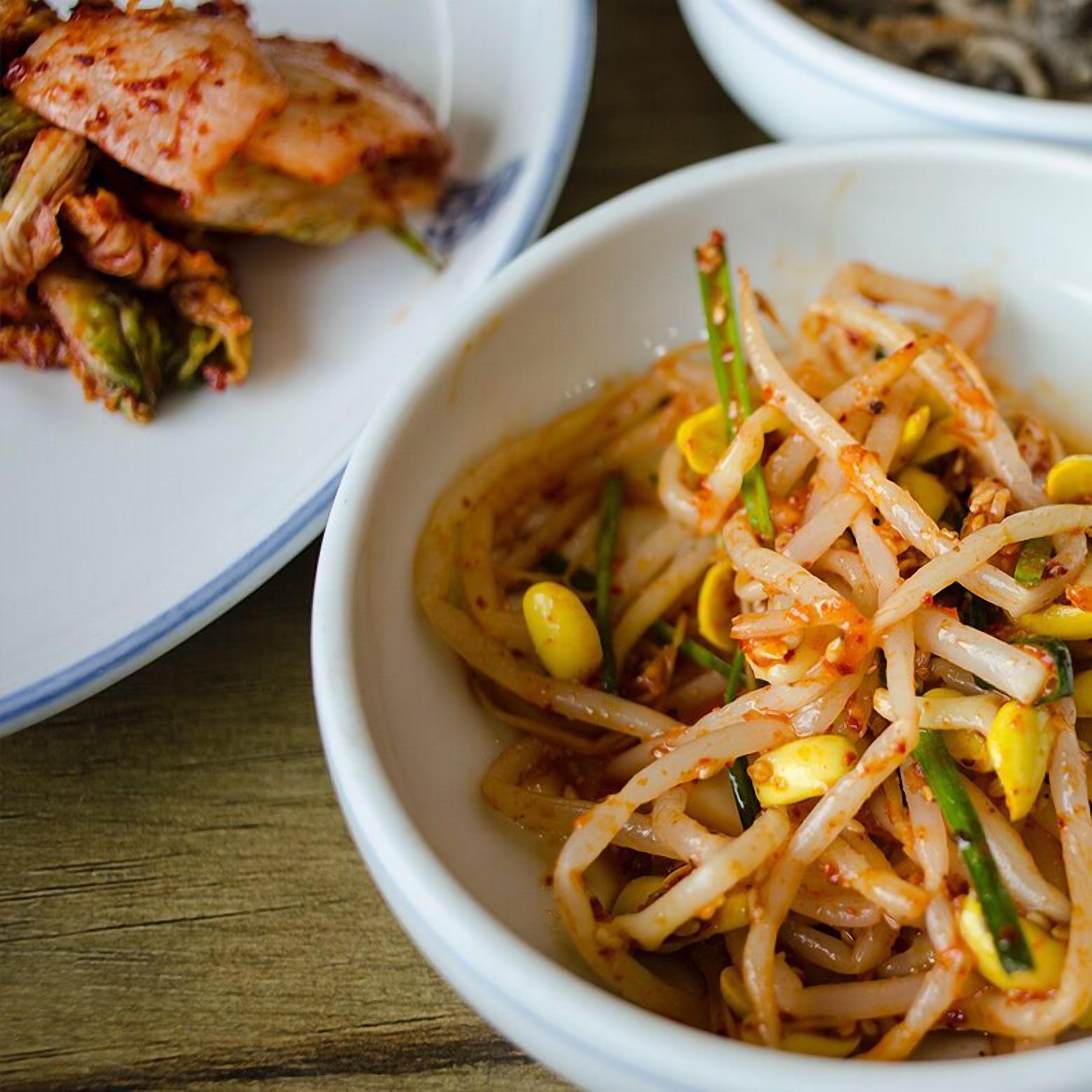 A bowl of spicy stir-fried noodles with vegetables.