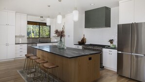 Una cocina moderna con una isla grande, electrodomésticos de acero inoxidable y vistas al exterior.