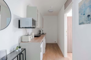 A compact kitchen with a microwave, toaster, and sink.