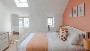 A bedroom with a bed, a desk, a chair, and two windows. - Quiet Mews 1-Bed · Fitzrovia · Sleeps 4 (Greater London)