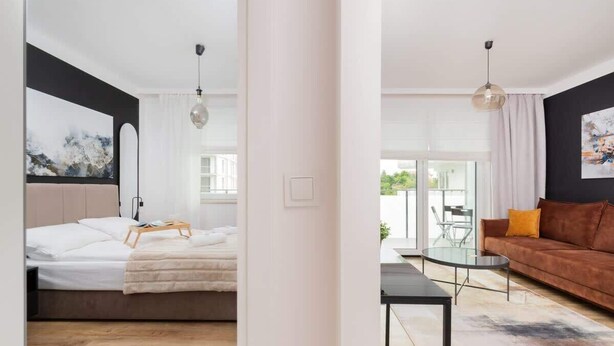 Een moderne hotelkamer met een bed, nachtkastje en uitzicht.