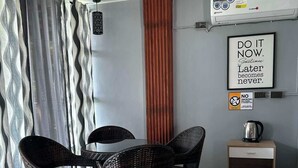 A dining area with a table and chairs, a wall-mounted air conditioner, a framed motivational quote, and a no-smoking sign. - Isla Del Antoño (Cavinti)