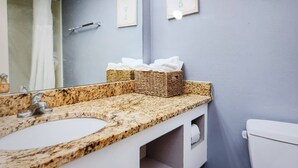 A bathroom with a granite countertop, a white sink, a mirror, a towel rack, and a toilet. - Oceanfront Efficiency T507 (Myrtle Beach)
