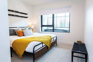 Ein Schlafzimmer mit einem Bett, einem Fenster, einer Bank und Skiern an der Wand.