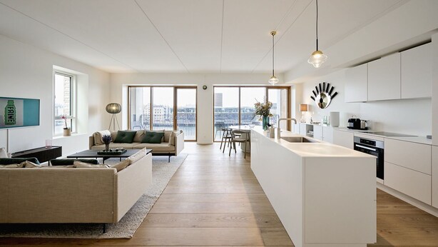 En moderne lejlighed med stue, spiseområde og køkken.
