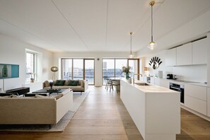 A modern apartment with a living room, dining area, and kitchen.