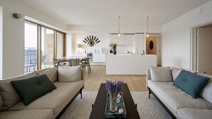 En moderne stue med to sofaer, et sofabord og et spiseområde med et rundt bord.