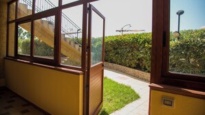 Ein Korridor mit großen Fenstern, einer Treppe und einem gepflegten Gartenbereich.