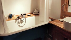 A bathroom with a bathtub, a wooden vanity, a sink, and two framed certificates on the wall. - Savoie, St François Longchamp, Très Grand Appartement de 180 m2, 12 Couchages (Saint-François-Longchamp)