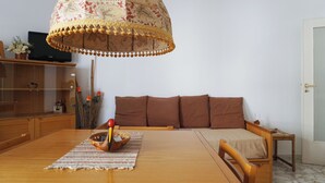 A dining area with a wooden table, a patterned table runner, and a decorative hanging lamp.