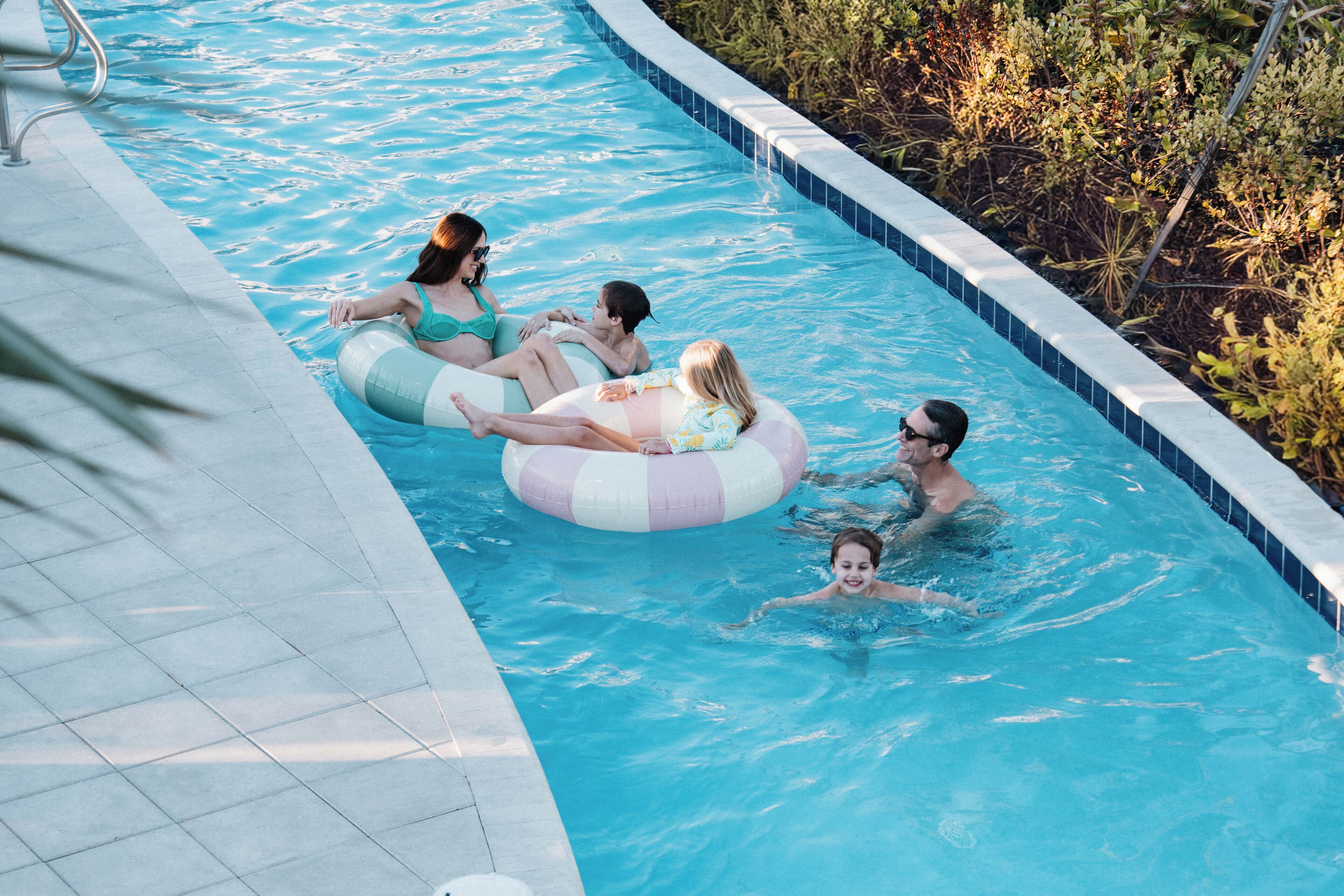Una piscina con bordes y solárium azulejados.
