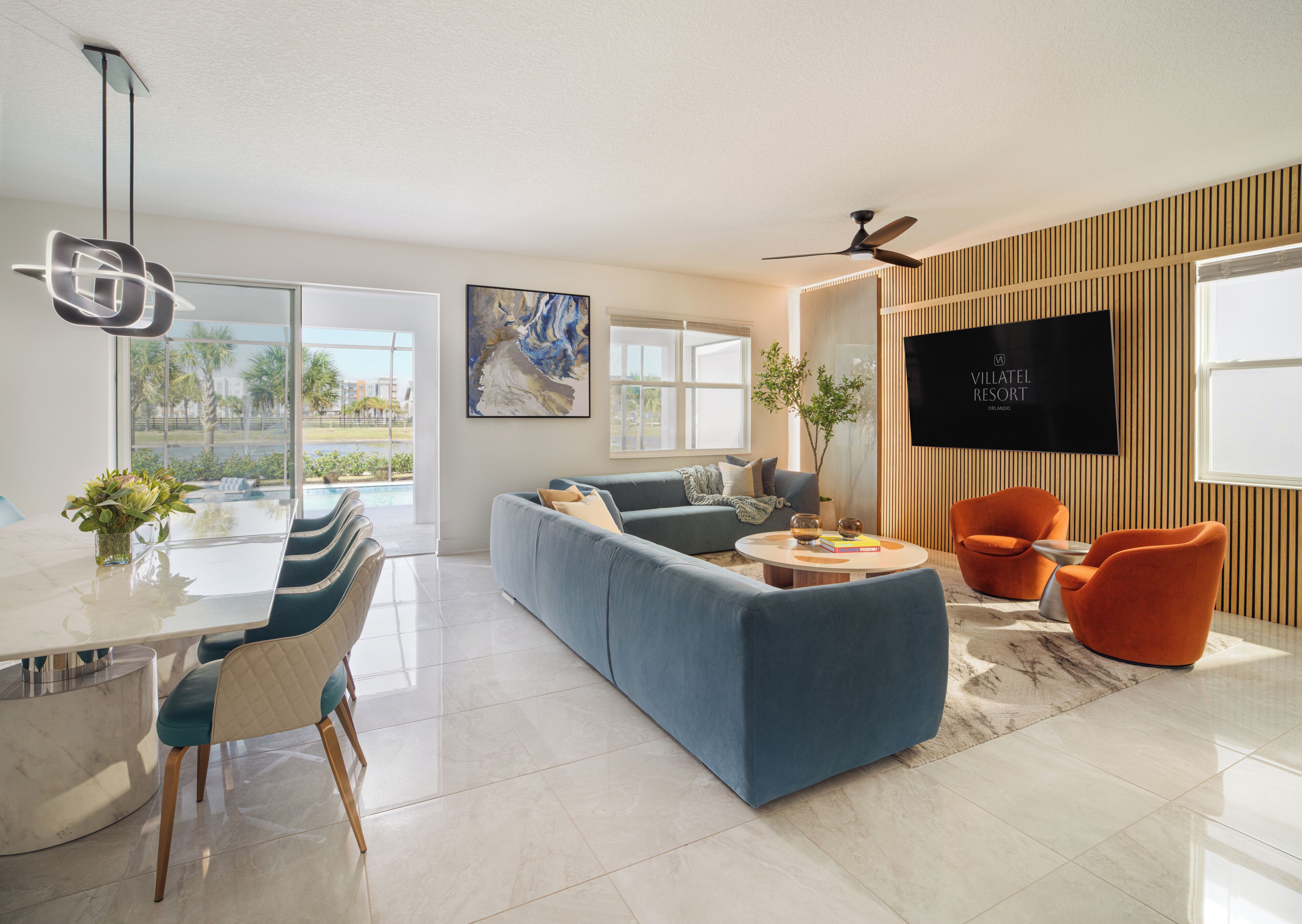 A modern living room with a sofa, chairs, a coffee table, and a TV.