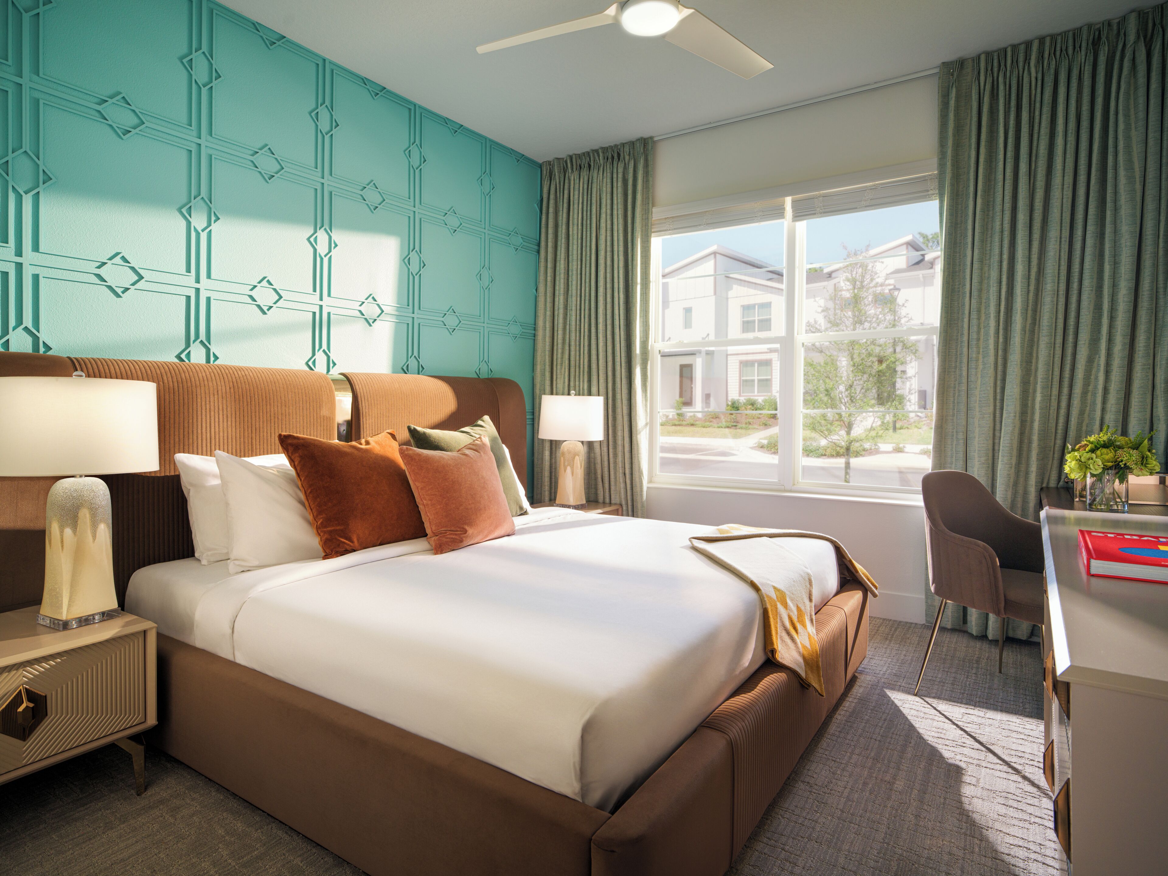 A hotel room with a large bed, two bedside tables, a desk, and a chair.