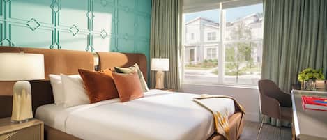 A hotel room with a large bed, two bedside tables, a desk, and a chair.