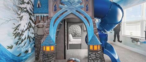 A room with a castle-themed play area, including a slide and a book on the floor.