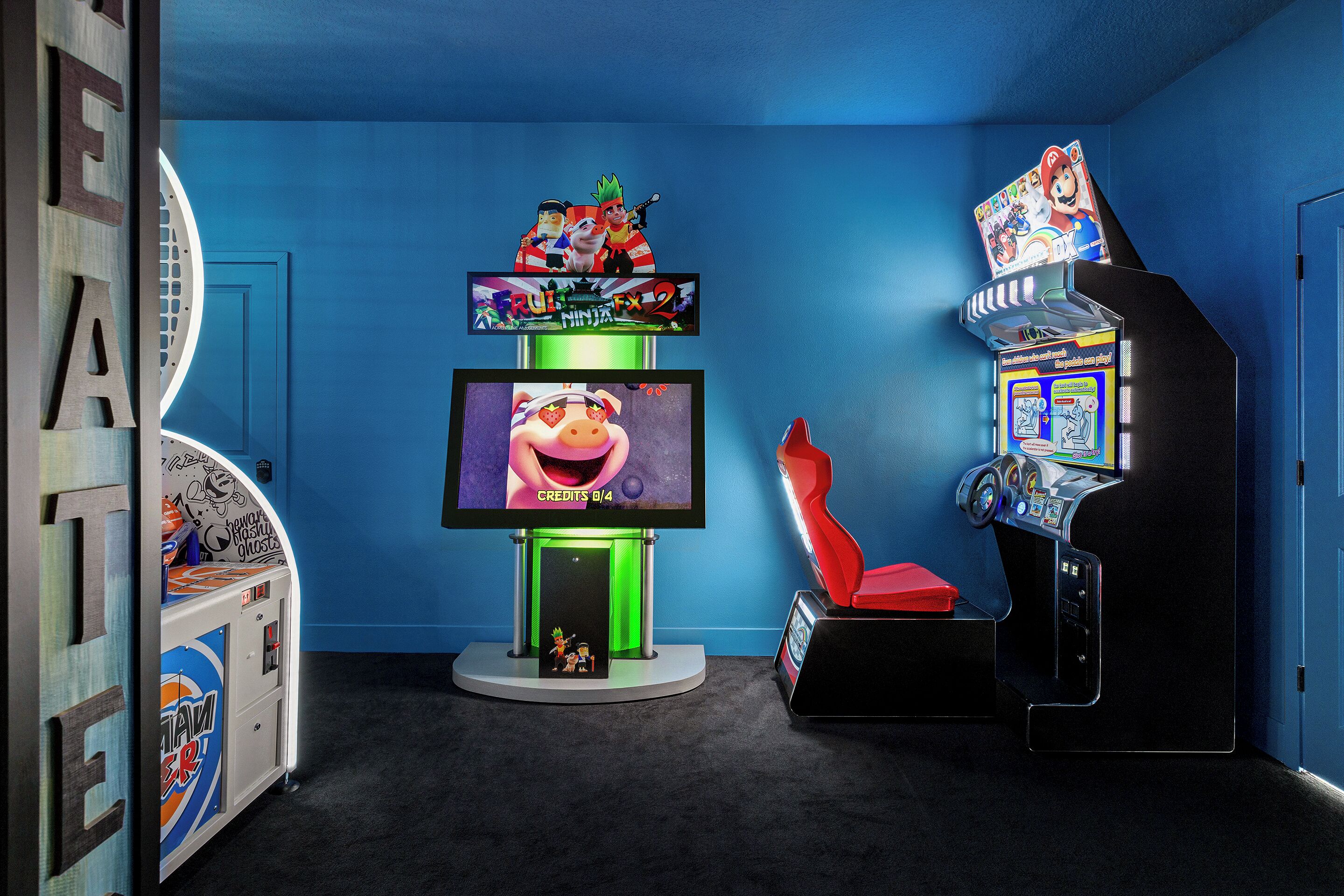 Une pièce dotée d’un grand écran de télévision, de jeux d’arcade et d’une porte au motif circulaire.