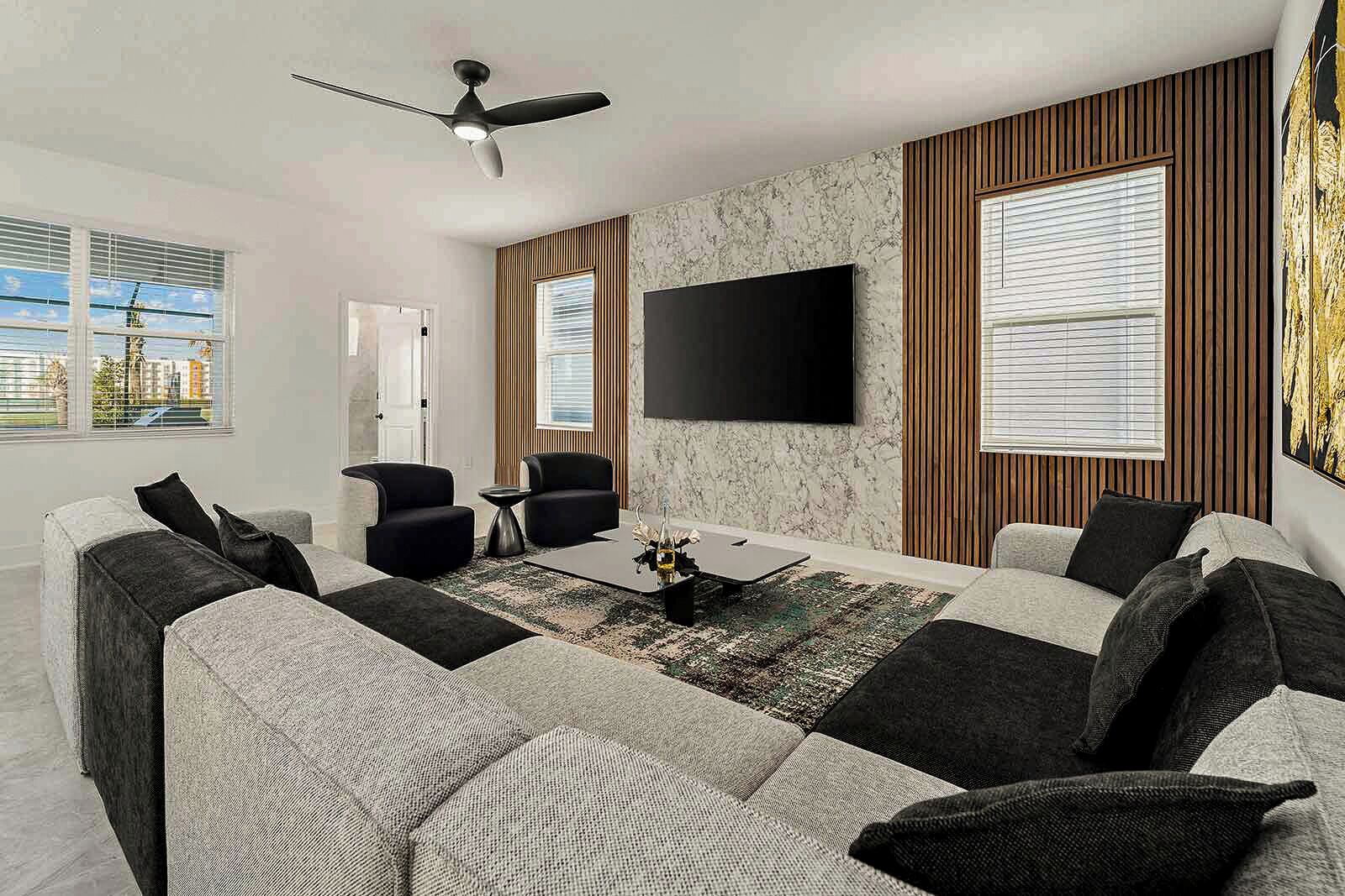Ein modernes Wohnzimmer mit einer Sofagarnitur, einem Couchtisch und einem flachbildfernseher an der Wand.