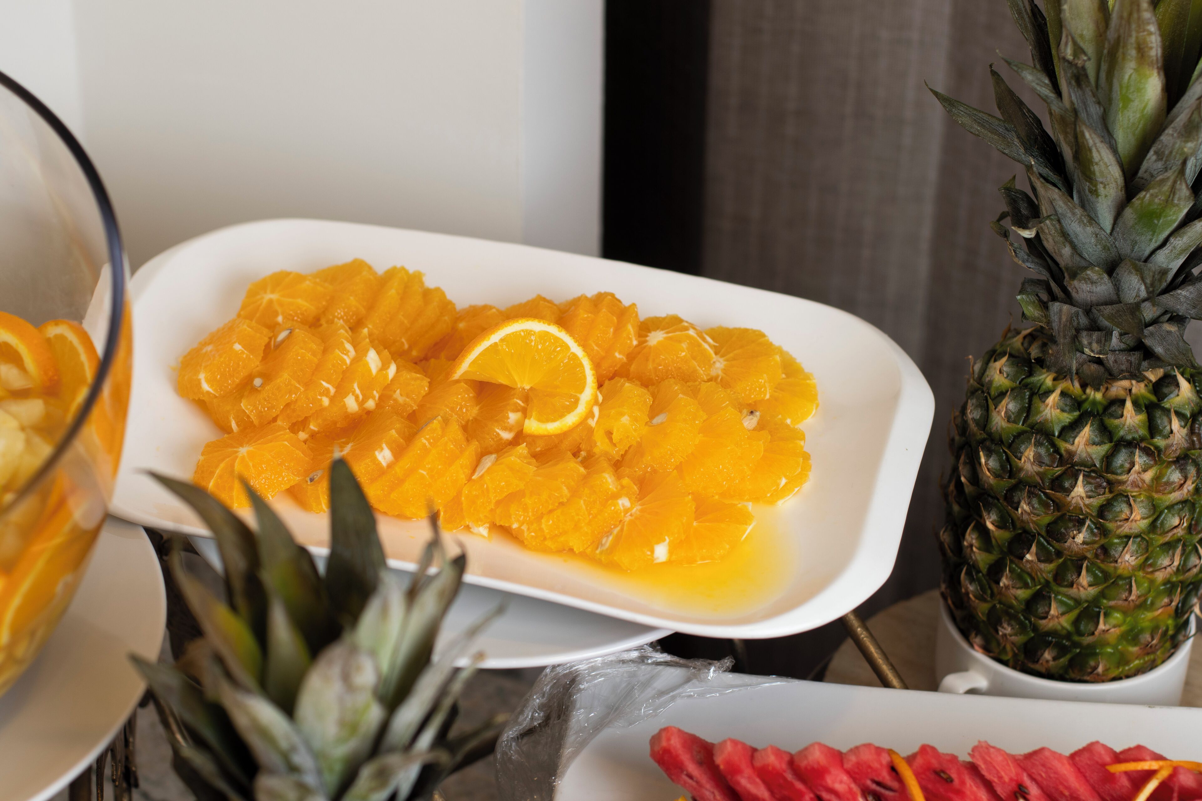 Un plato blanco con rodajas de naranja y piña.