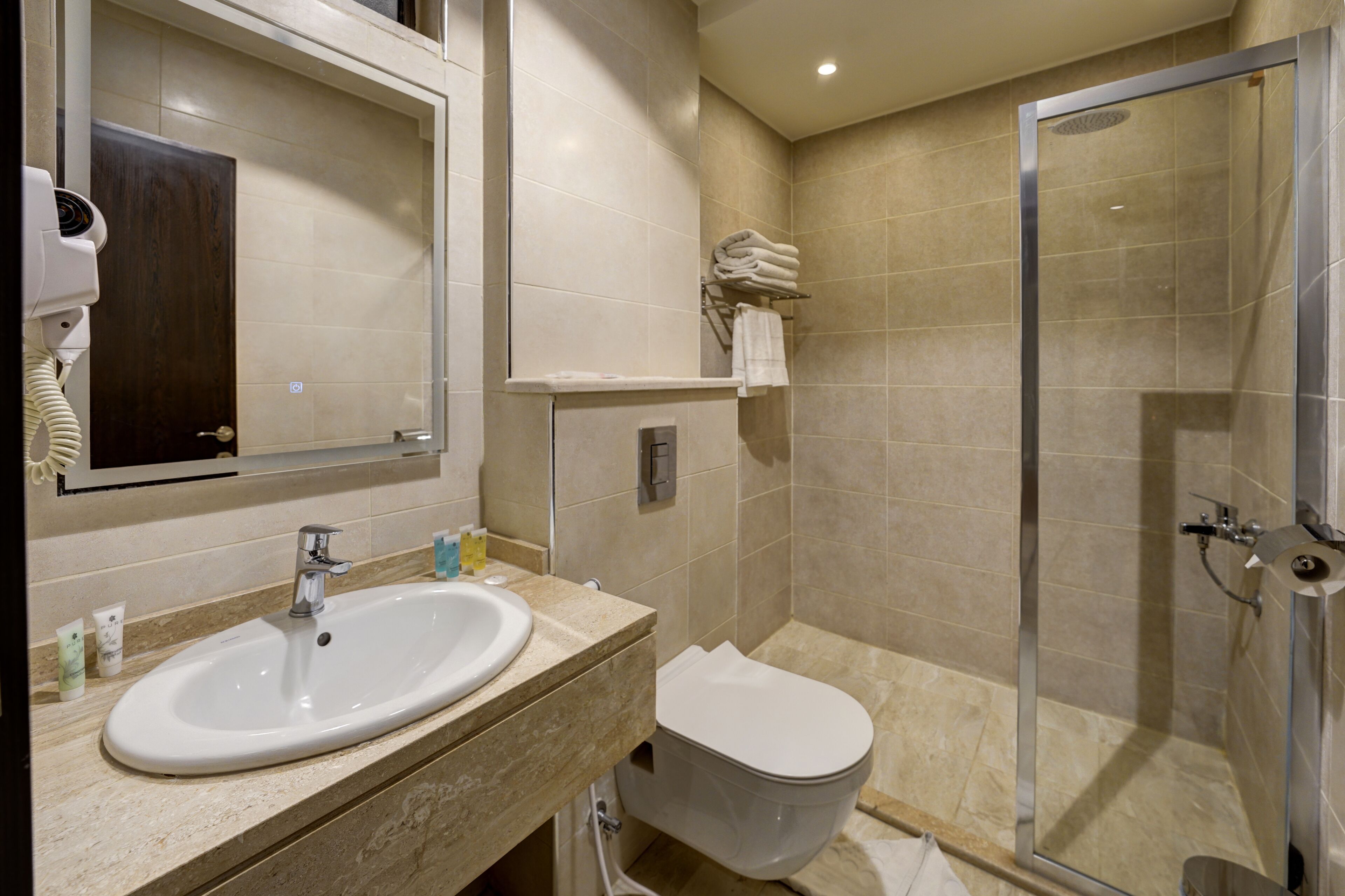 A modern bathroom with a sink, toilet, and glass shower enclosure.