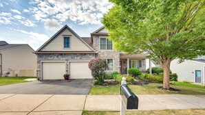 A two-story house with a stone facade, a garage, and a well-maintained lawn.