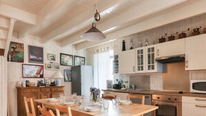 Una cucina con mobili in legno, un tavolo da pranzo per quattro persone e un forno a microonde.