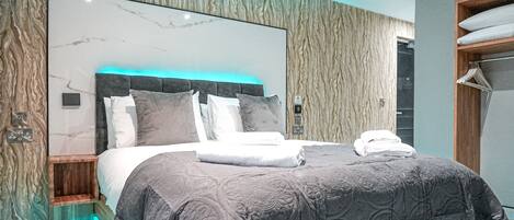 A modern bedroom with a marble headboard, a glass floor, and a wooden wardrobe.