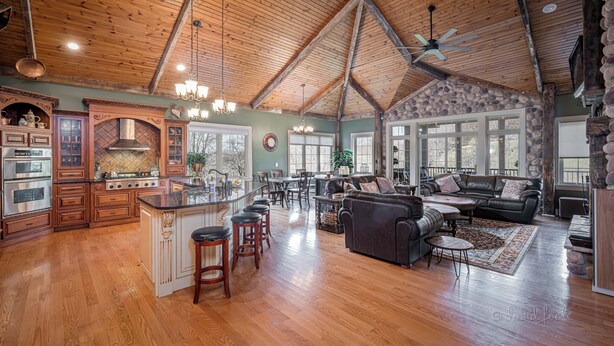 A spacious kitchen with a central island, wooden flooring, and a high ceiling with exposed beams. - Enjoy your Private 4 Acres @ Owl Creek - Hot Tub, Fire Pit (Galena)