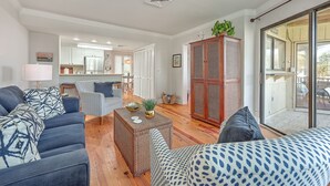 A modern living room with a sofa, a coffee table, and a cabinet. - Port O' Call E203 - Ocean View Perfection! (Isle of Palms)