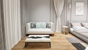 A modern living room with a sofa, a coffee table, a side table, and a framed picture on the wall.