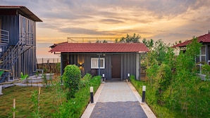 A modern building with a red-tiled roof, a staircase, and a pathway leading to the entrance.