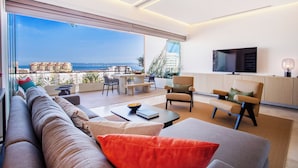 A modern living room with a large sliding glass door leading to a balcony with a city view. - Romantic Zone’s Largest Rooftop | Luxe Ocean Views (Puerto Vallarta)