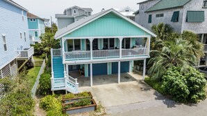Une maison à deux étages dotée d’un balcon, d’un porche avant couvert et d’un petit jardin.