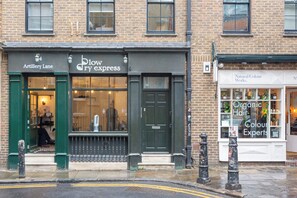A building with storefronts including 'Artillery Lane' and 'Blow Dry Express'. - 2 Bedroom Service Apt in Artillery Lane (London)