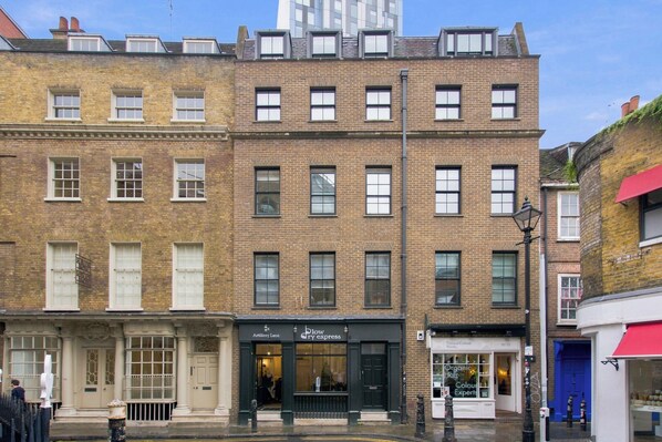 A multi-story brick building with a storefront on the ground floor. - 2 Bedroom Service Apt in Artillery Lane (London)