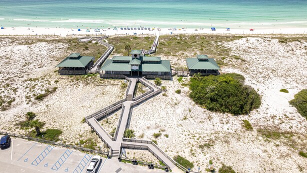 An aerial view of a resort with multiple buildings, a beach, and a parking area.