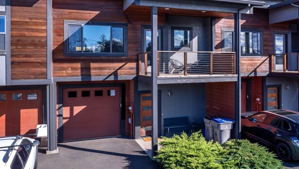 A modern multi-story building with a wooden facade, balconies, and a garage. - Hull Street Loft 2 Bedroom Townhouse by RedAwning (Hood River)