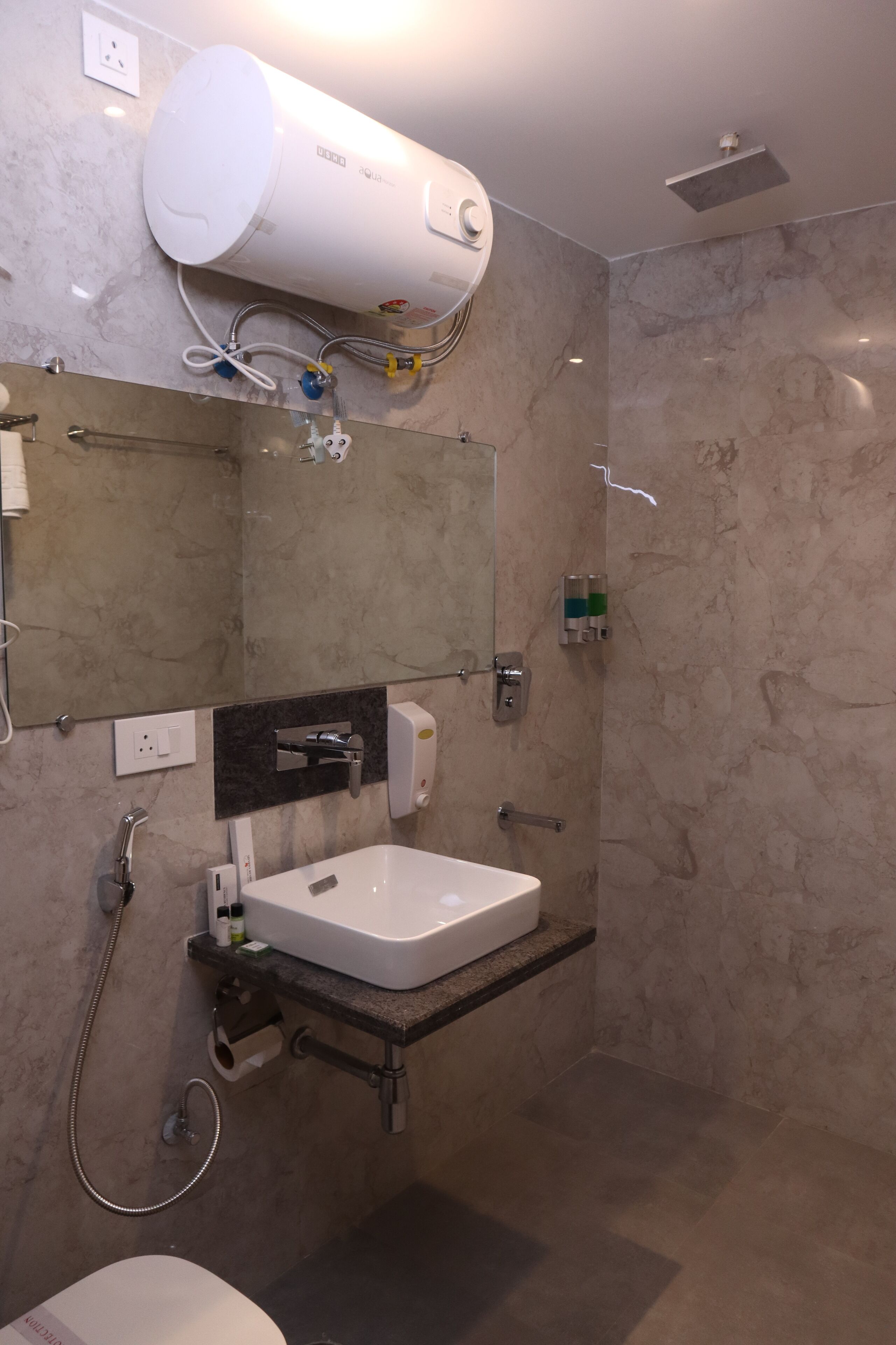 Ein modernes Badezimmer mit integriertem Waschbecken, einem Spiegel, einem Handtuchhalter, einer Dusche und einer Toilette.
