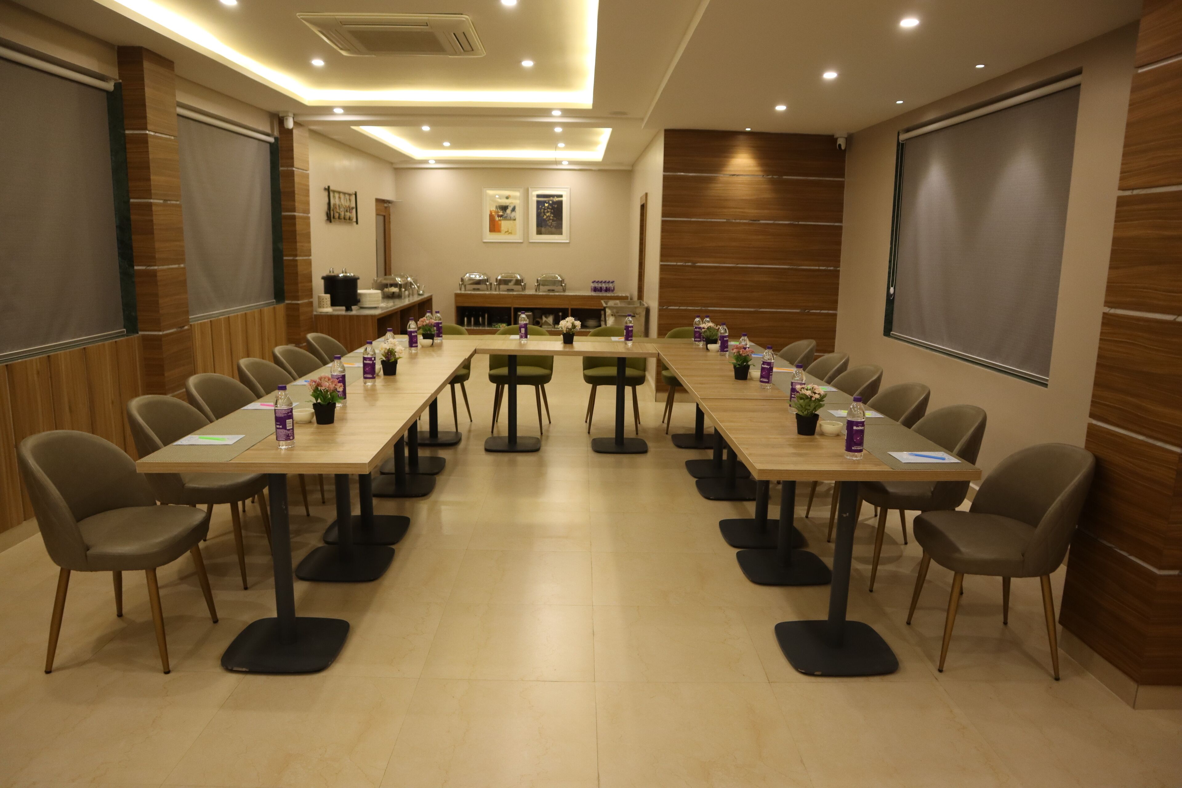 A conference room with long tables, chairs, and a presentation screen.