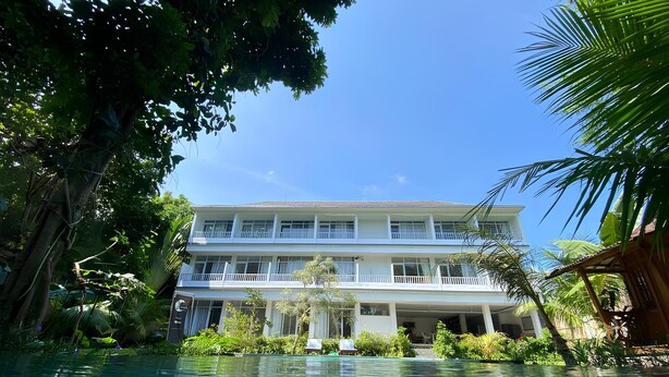 Un edificio de dos pisos con una piscina al frente.