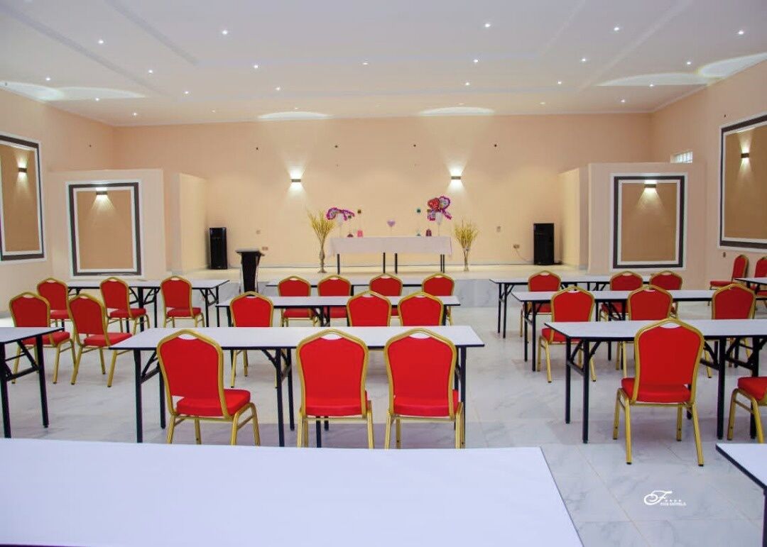 A conference room with multiple tables and chairs, arranged in rows.