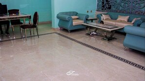 A hotel room with a teal color scheme, a dining area with a table and chairs, and a decorative wall with intricate patterns. - Fox Premium Hotel Jos  (Jos)