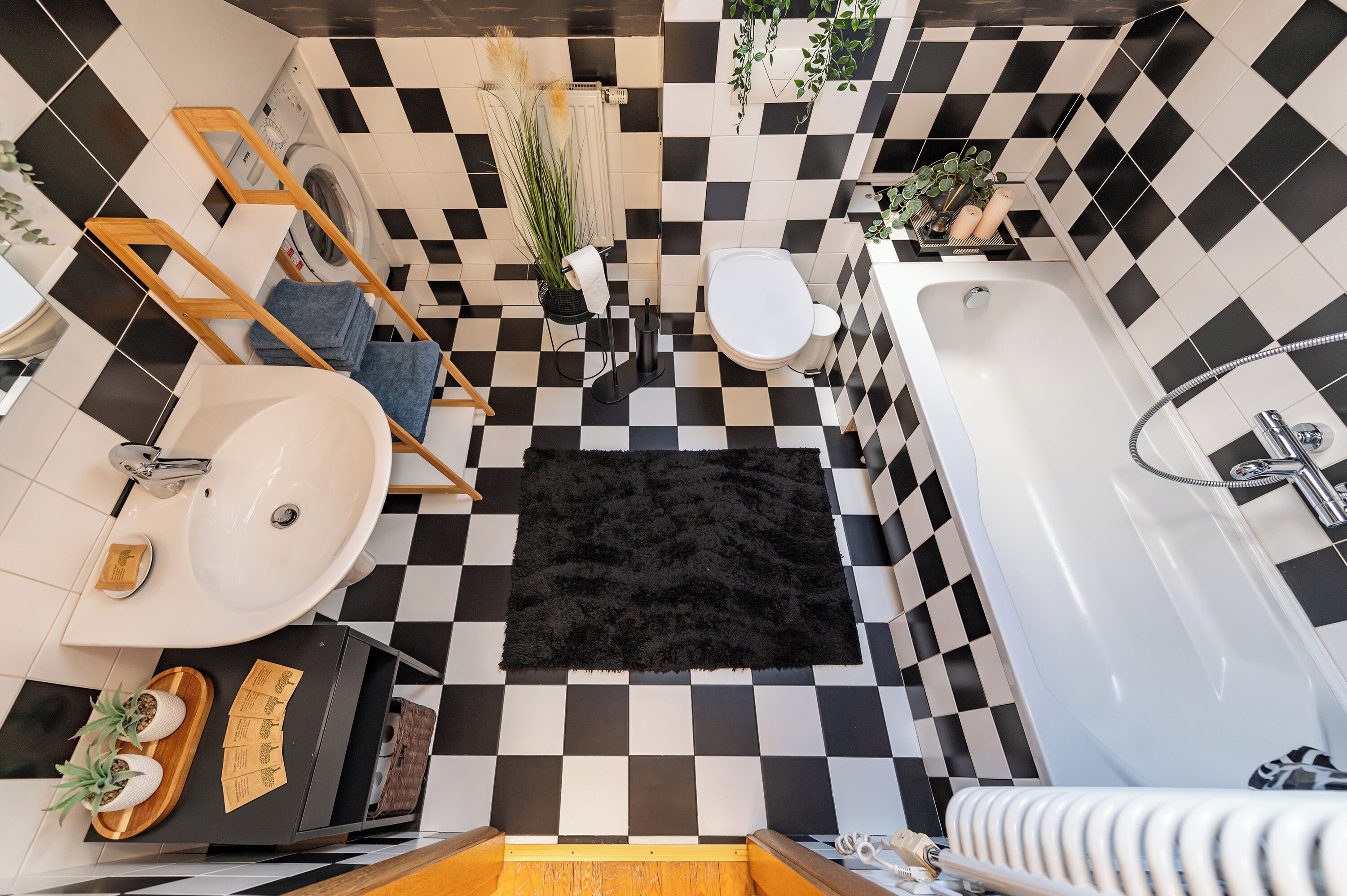 A bathroom with a checkered floor, a white sink, a bathtub, and a toilet.